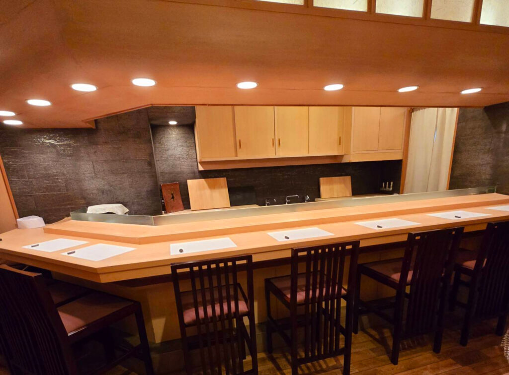 Private and intimate sushi counter with warm lighting – Sushi 22 Osaka 北新地の落ち着いた店内